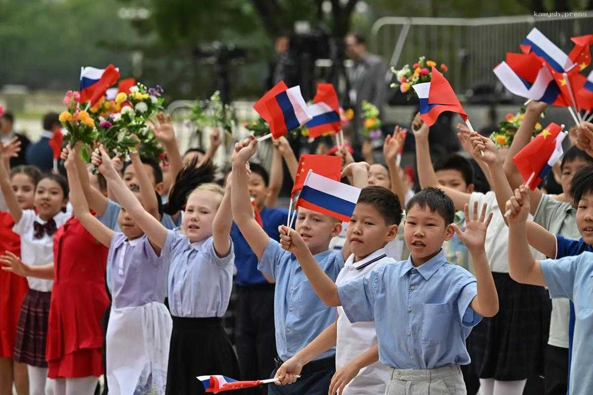 Школьники Пекина приветствовали Путина с цветами и флажками
